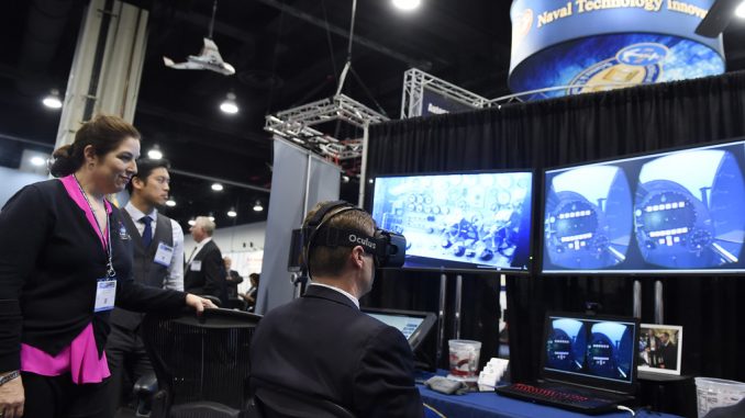 "A vendor explains mixed reality to an attendee at the 2016 Sea-Air-Space Exposition." by Official U.S. Navy Imagery is licensed under CC BY 2.0.